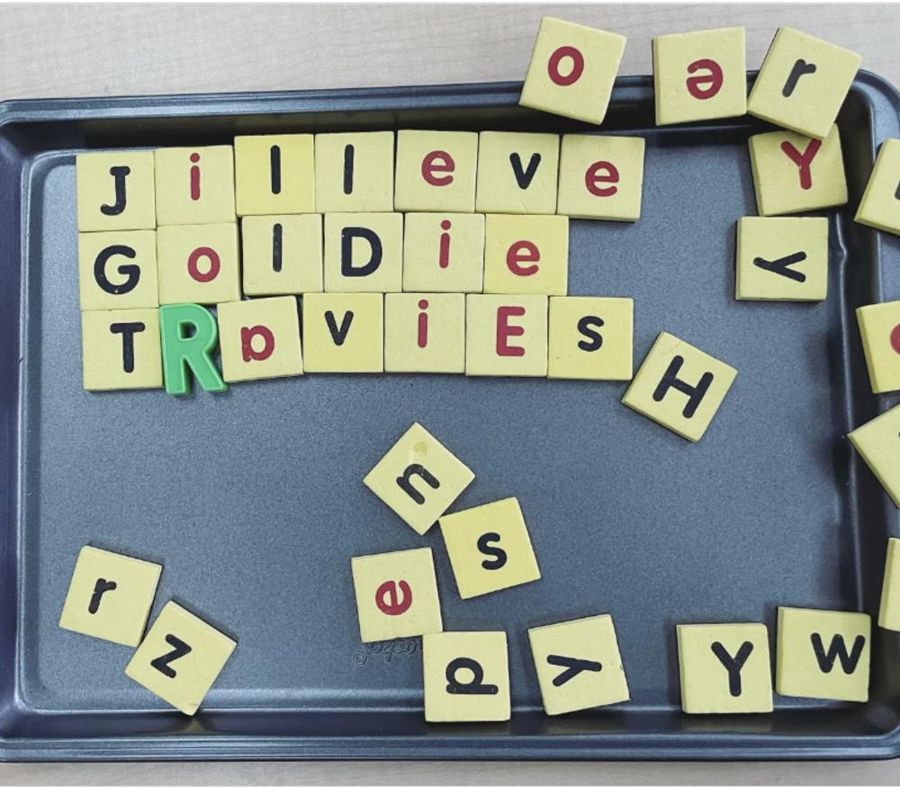 A metal baking sheet with magnetic letter tiles